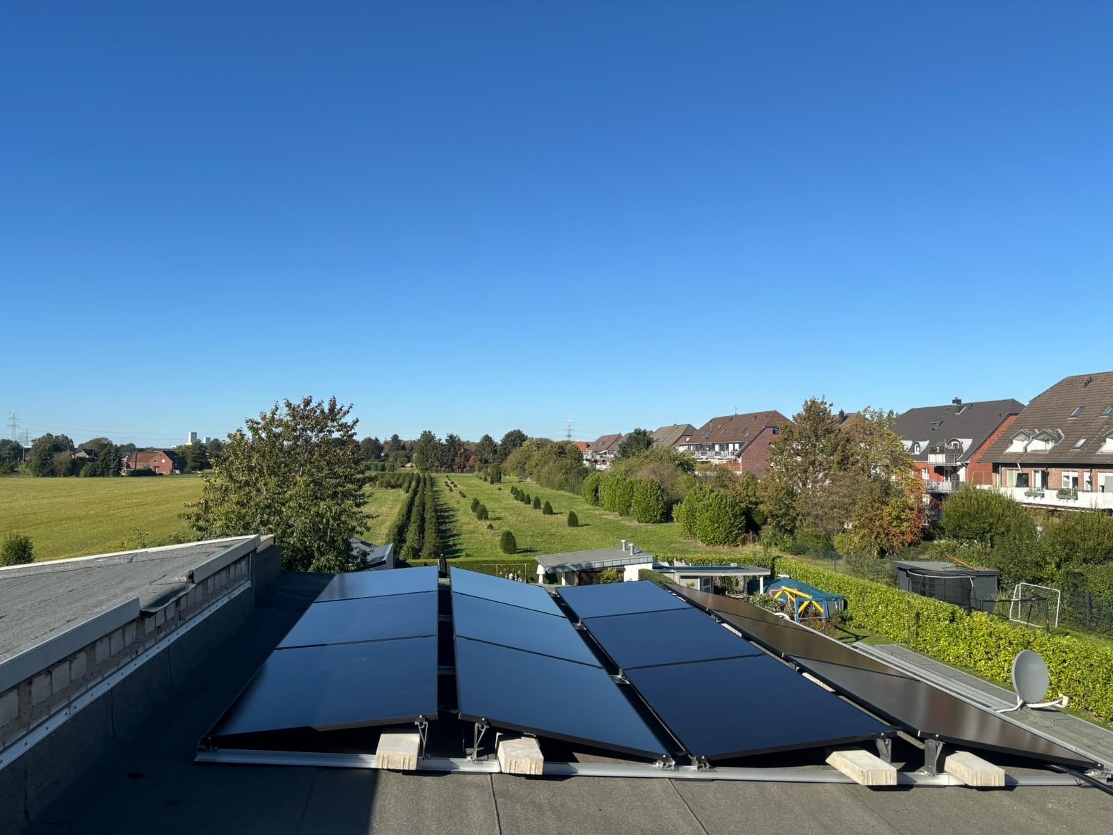 Photovoltaikanlage auf einem Flachdach mit Blick über Felder
