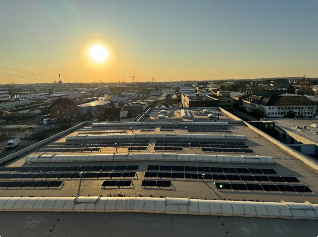Flachdach einer Gewerbehalle mit Photovoltaikmodulen bei Sonnenuntergang