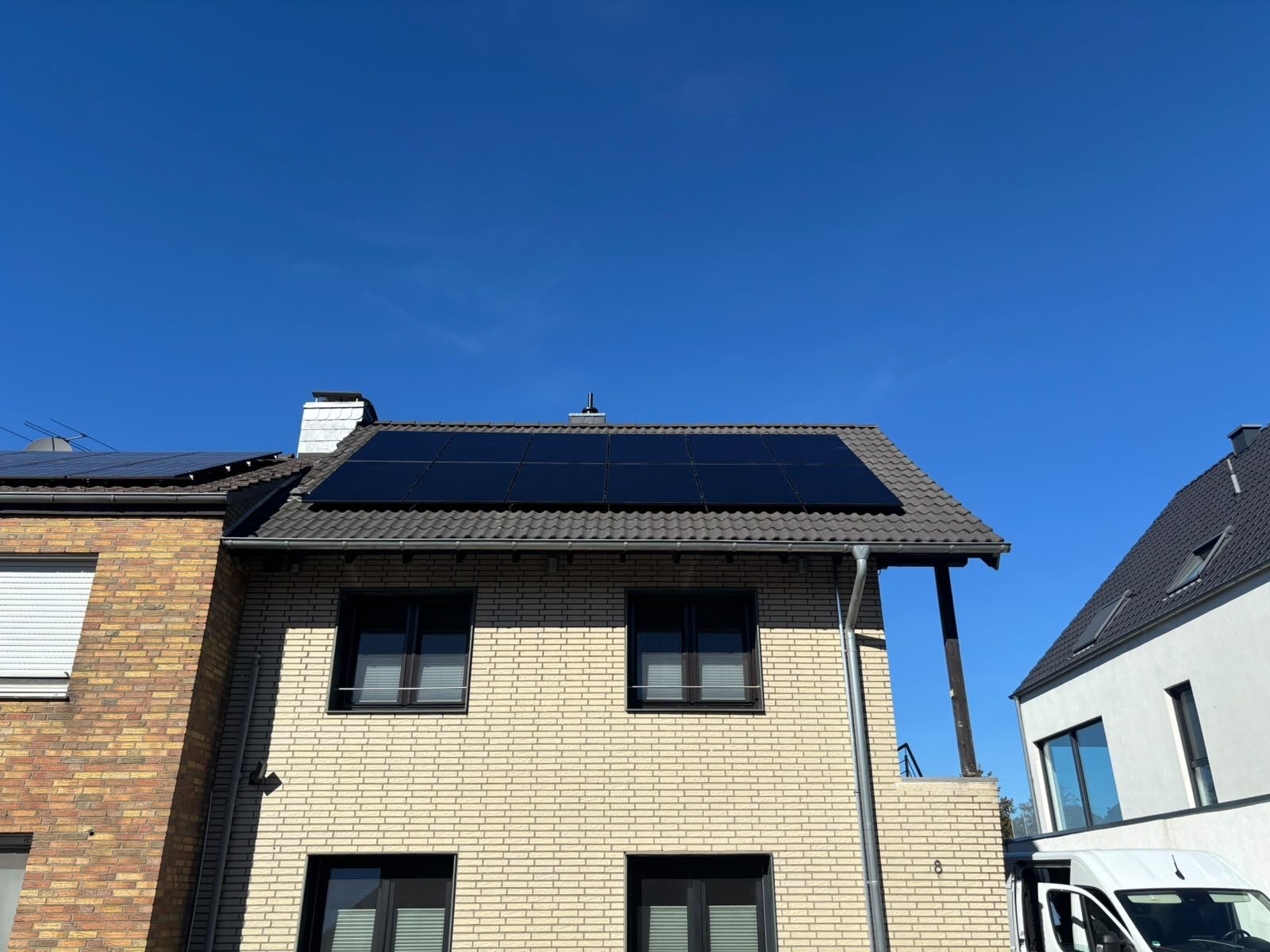 Wohnhaus mit schwarzen Solarmodulen auf dem Satteldach