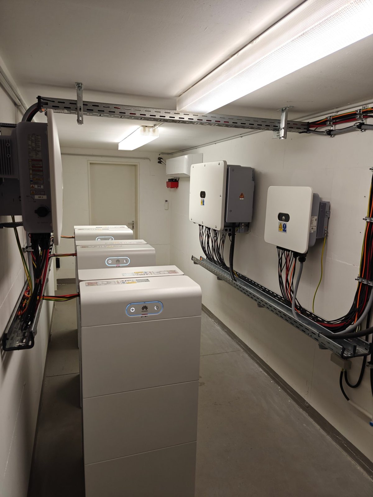 Technikraum mit Batteriespeichern, Wechselrichtern und sauber verlegten Kabeltrassen