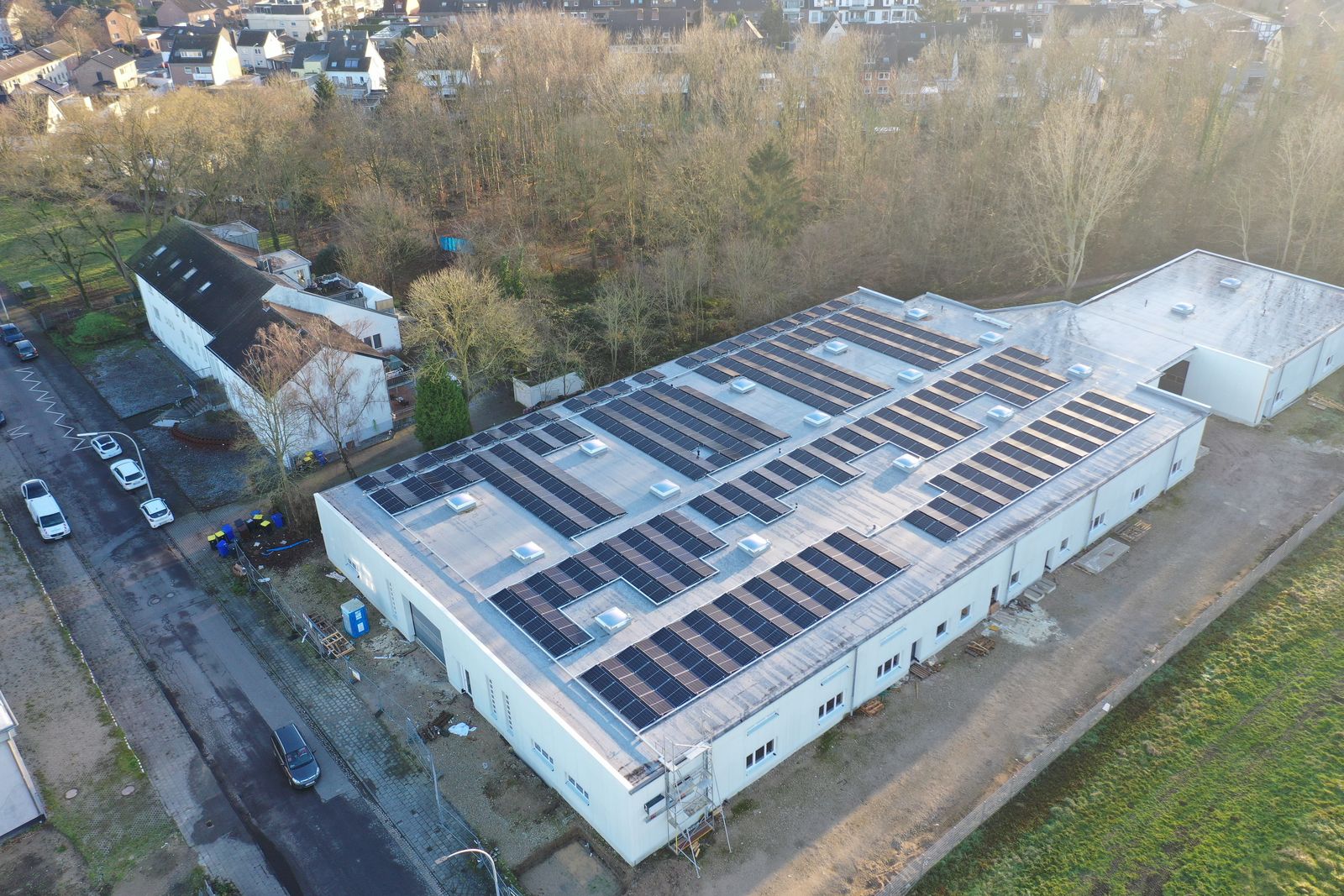 Gewerbehalle mit großer Photovoltaikanlage auf dem Flachdach, Luftaufnahme