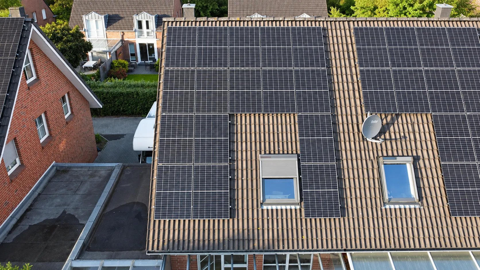 Ziegeldach mit Photovoltaikmodulen und Dachfenstern, Drohnenaufnahme